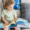 Un bambino che legge il libro della sua mamma sul suo futuro.