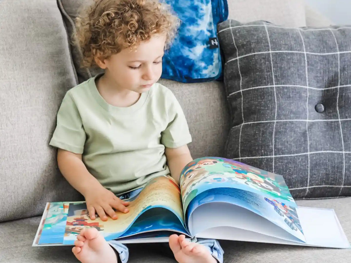 Un bambino che legge il libro della sua mamma sul suo futuro.