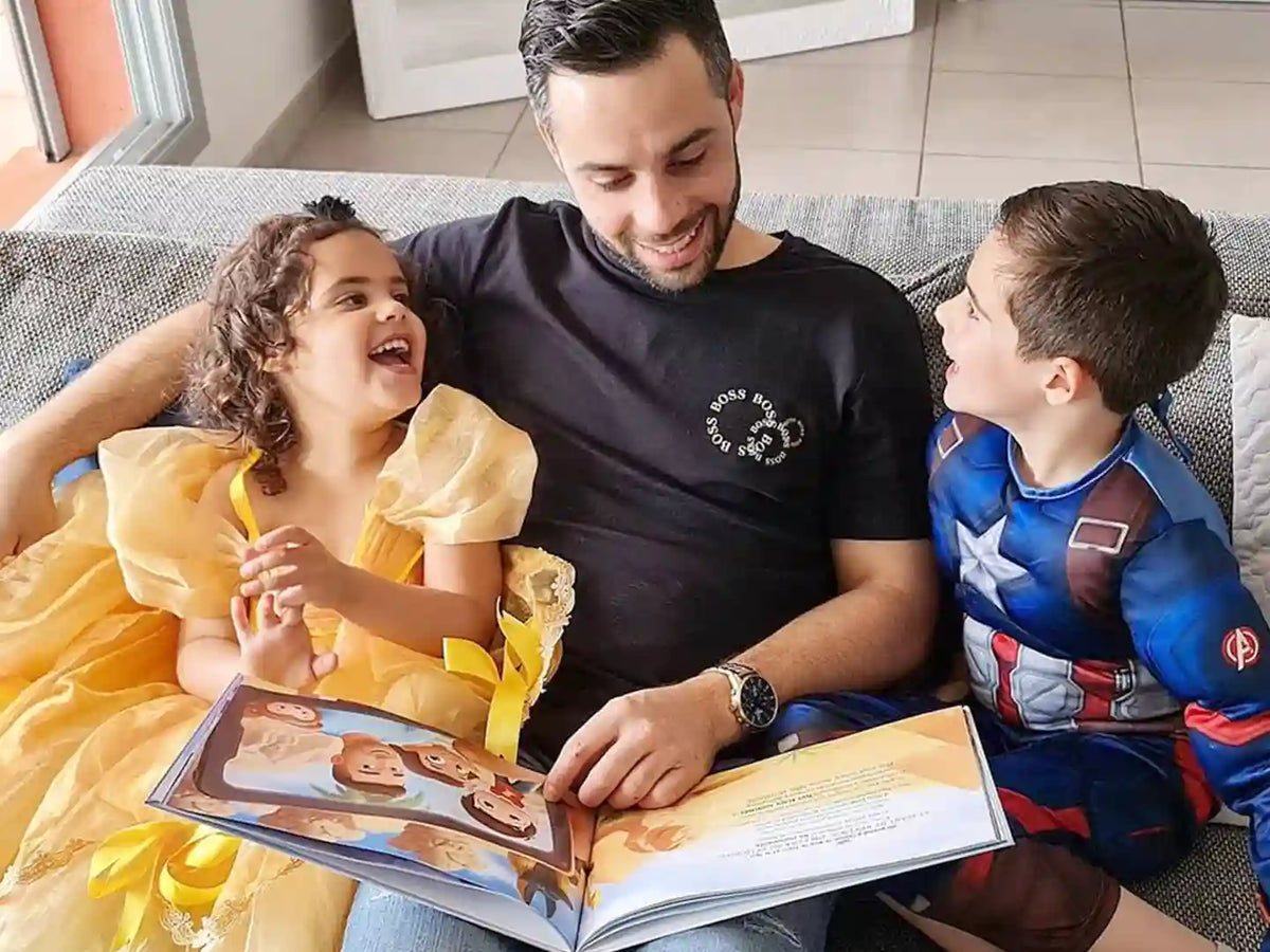 Papà, figlio e figlia leggono un libro personalizzato di Urrà Eroi fatto apposta per loro! Questo regalo personalizzato per la Festa del Papà è pieno di storie che aiuteranno a rafforzare il loro legame e creare nuovi ricordi!