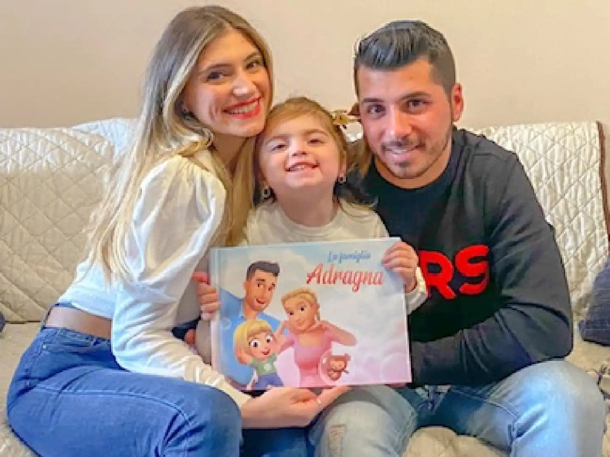 Una famiglia seduta  sul divano con il loro libro personalizzato per famiglie, un regalo carino per ogni occasione.