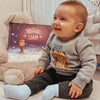 Un bambino che sorride con il simpaticissimo regalo di Urrà Eroi per Natale. 
