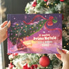 Libro di Natale personalizzato “Il nostro Primo Natale 2025” con Elisa & Mamma, tenuto davanti a un albero decorato.